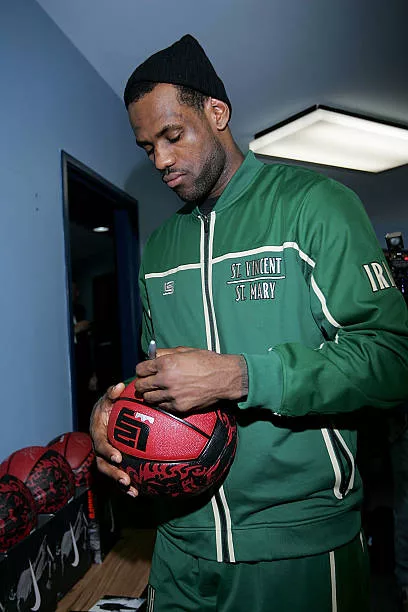 Superstar LeBron James signs basketballs for kids before speaking to reporters at the Dallas Boys & Girls Club on February 13, 2010 in Dallas, Texas.